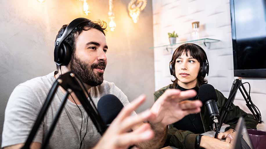 Two people in the studio recording a podcast.