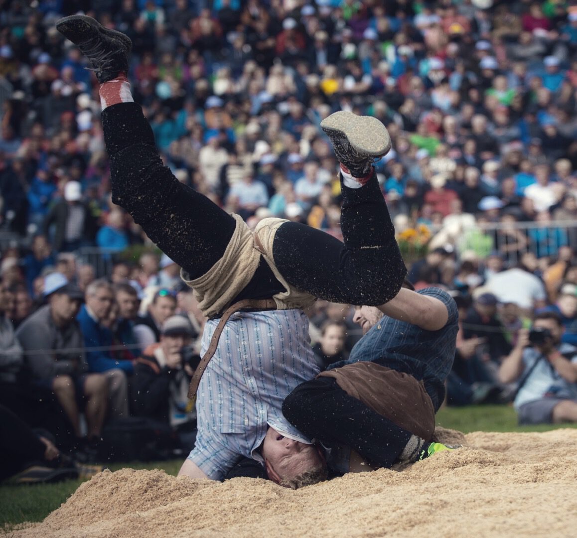 Zwei Männer beim Schwingen, einer steht Kopf
