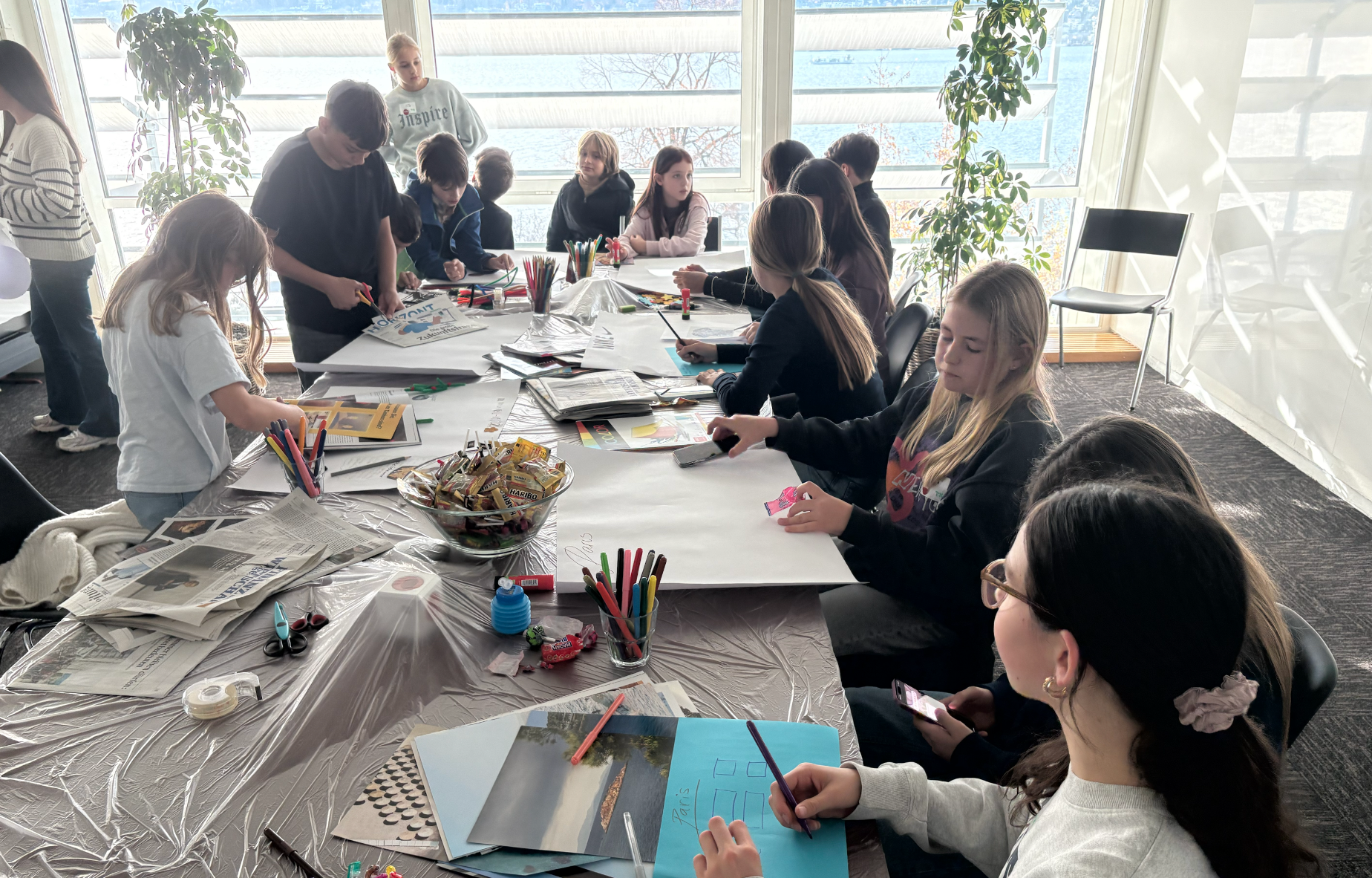 Schnuppertag bei Goldbach. Kinder sitzen um einen grossen Tisch und basteln.