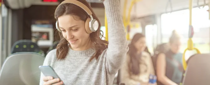 Une femme est dans les transports publics et écoute de l’audio