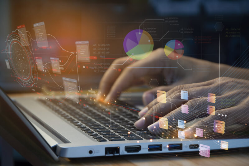 Hände an einer Laptop-Tastatur mit Lichteffekten.