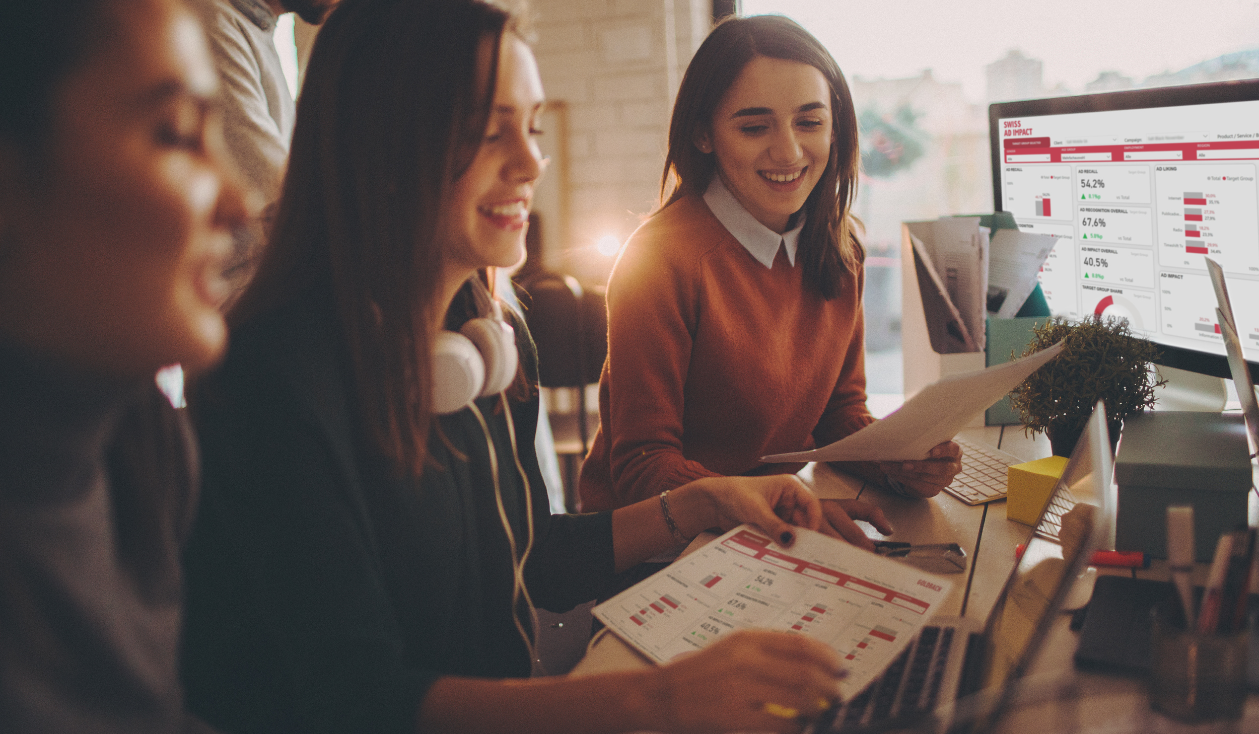 Trois jeunes femmes assises devant l’étude Swiss Ad Impact à l’écran