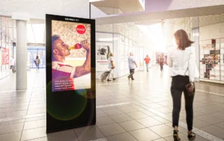 Screen in shopping center with people walking past