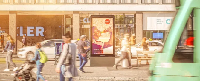 Schermo accanto alla fermata del tram con persone che passano