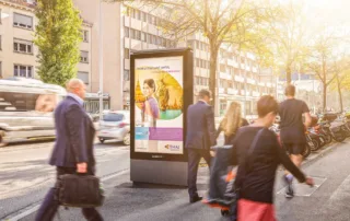 Screen on the street with people walking past