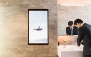 Advertising space visible and person washing hands