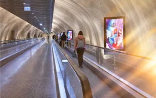 Screens at Geneva Airport next to the moving walkway.