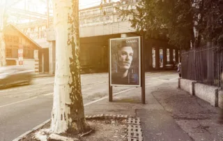 Poster by the road in Geneva and a car driving past