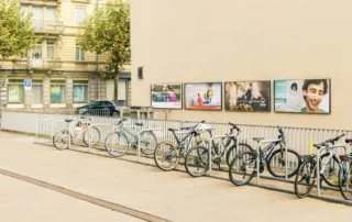 Several poster sites in front of a bicycle rack.
