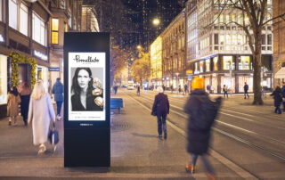 Digital screen on Bahnhofstrasse with people walking by