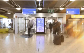 Advertising space and people walking with suitcases