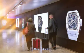 Advertising space and people walking with suitcases